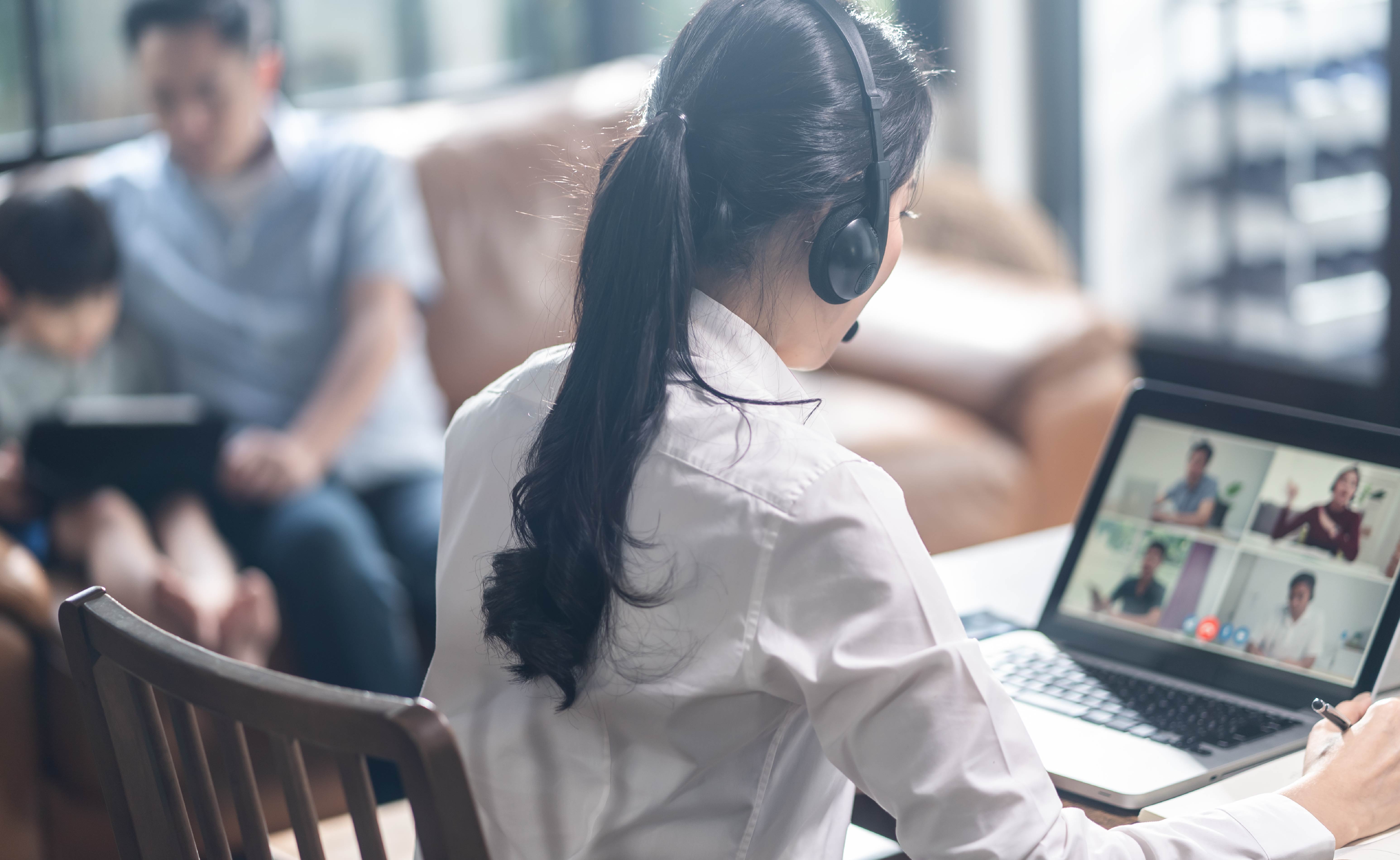 A professional wearing a headset and joining a video call from home.